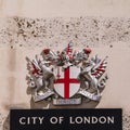 Coat of arms of the City of London mounted on a background of white stone