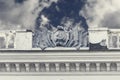 Coat of arms and flags of USSR of plaster on facade of old building. Crimea, Sudak - 10 October 2020