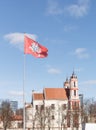 Coat Of Arms Of Lithuania Flag. Knight On Horse With Sword And Shield On Red Background. Blue Sky With Clouds And Church