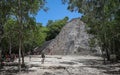 Visitors climb an ancient pyramid at Coba ruins. Royalty Free Stock Photo