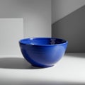A cobalt blue ceramic bowl with a glossy finish is positioned on a white and gray Royalty Free Stock Photo
