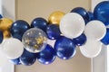 Cobalt blue, gold, and white gold balloon swag with clear balloon with gold confetti Royalty Free Stock Photo