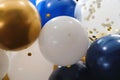 Cobalt blue, gold, and white gold balloons with clear balloon with gold confetti, horizontal Royalty Free Stock Photo