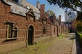 Cobble street along a park with medieval brick houses in Antwerp beguinage