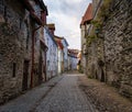 Cobbled alley with medieval houses and stone wall in Tallinn