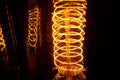 Cobbled classic incandescent Edison light bulbs with visible glowing wires in the night