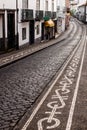 Cobbled lane with black and white mosaic pavement calcada in Ponta Delgada, Azores, Portug