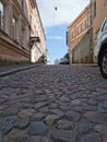 A cobbled, narrow, ancient street of the city of Vyborg on a sunny summer day