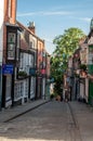 A cobbled narrow street full of old brick houses with wooden shop windows in Lincoln, England. Royalty Free Stock Photo