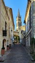 Cobbled shopping street with bell tower of Saint Emilion church, France. Translation: Golden grass Royalty Free Stock Photo