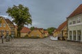 Cobbled square with roses and vintage timber framed houses in the dusk evening light