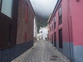 Cobbled street with colorful traditional houses in the village of Agulo located in green valley at north coast. Cloudy