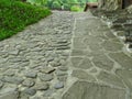 Cobbled street and green grass. Grey paving stones. Cobblestones. Pavers.