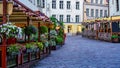 Cobbled street with wooden benches with flowers in Tallinn Royalty Free Stock Photo