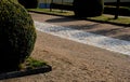 Cobbled strip of beige brown cobblestone stones. around is a park gravel road of the castle`s honorary courtyard. Centrally symmet Royalty Free Stock Photo