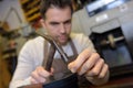 Cobbler hammering nail into heel shoe