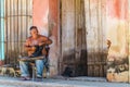 Cobbler repairing shoes on a street in Trinidad, Cuba