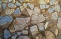 Cobbles close-up with a green grass in the seams. Old stone pavement texture. Royalty Free Stock Photo