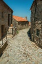 Cobblestone alley on slope and stone old houses Royalty Free Stock Photo