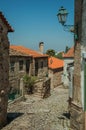 Cobblestone alley on slope and stone old houses Royalty Free Stock Photo
