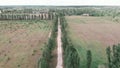 Cobblestone gravel road in countryside with fields and meadow. Epic rural landscape, aerial view. Green field and meadow with empt