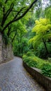 Cobblestone path winds through lush greenery and mature trees, creating a tranquil park or garden scene Royalty Free Stock Photo
