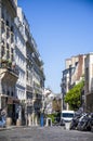 Cobblestone road on a street with old multi-story buildings and an impromptu windmill in the Montmartre hills in Paris Royalty Free Stock Photo