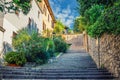 Cobblestone staircase with stairs, green trees, bushes and flowers, street lights