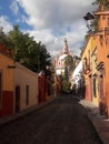 Cobblestone street with colorful buildings and church views in colonial San Miguel de Allende Guanajuato Mexico calle Aldama Royalty Free Stock Photo