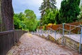 A cobblestone street with a fence and stairs with railings going down the street in Germany Royalty Free Stock Photo