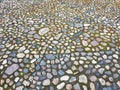 Cobblestone street with grass between the stones, multi-colored cobblestones, rubble masonry, texture or background Royalty Free Stock Photo