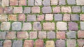 Cobblestone street with grass between the stones, texture or background Royalty Free Stock Photo