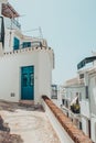 Cobblestone street with houses with blue doors in Frigiliana Malaga spain