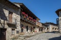 Cobblestone street with picturesque stone residential buildings and flowered balconies in Puebla de Sanabria, sPAIN