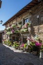 Cobblestone street with picturesque stone residential buildings and flowered balconies in Puebla de Sanabria, sPAIN