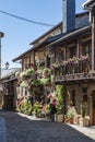 Cobblestone street with picturesque stone residential buildings and flowered balconies in Puebla de Sanabria, sPAIN