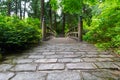 Cobblestone Path to Wood Bridge in manicured Japanese garden Royalty Free Stock Photo