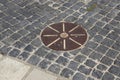 Cobblestones pavement with metal round detail Royalty Free Stock Photo