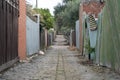 A coble stone alley in suburban melbourne with an old iron fence Royalty Free Stock Photo