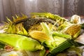 The cobs of sweet corn and the head of sunflower on the table in the sun Royalty Free Stock Photo