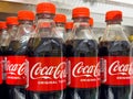Coca-cola bottles with red caps in refrigerated display Royalty Free Stock Photo