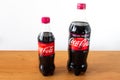 Coca-Cola Cherry and Coca-Cola Cherry Zero in plastic bottles on wooden table.