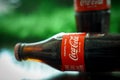 Ayutthaya, Thailand-25June2020: Coca-Cola Classic in a glass bottle and can on dark toned cement Background. Coca Cola, Coke is th