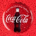 Coca Cola drink concept on a red background with a cap and a bottle with drops