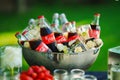 Coca Cola in a glass bottle in a toe with ice cubes with frozen flowers.