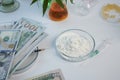 Dollars and Cocaine Flour in Glass Petri Dish on a Lab desk Royalty Free Stock Photo