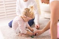 Cochlear implant for baby. Deaf child with hearing aid plays in living room.