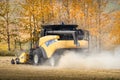 New holland combine harvesting a barley field in autumn colours during fall harvest