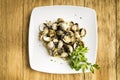 Cockles cooked with parsley and half a lemon on a white plate Royalty Free Stock Photo