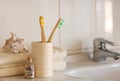 Cockleshell, Bath white cotton towels and bamboo toothbrushes on Blurred bathroom interior background with sink and faucet Royalty Free Stock Photo